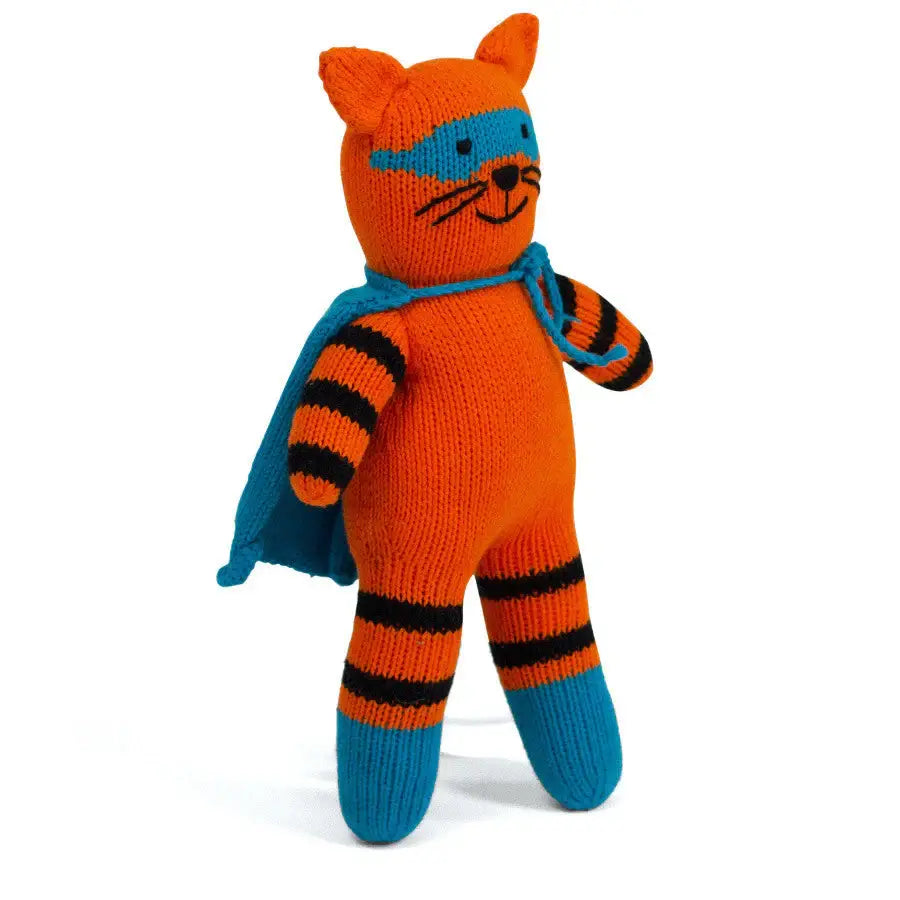 Knitted toy tiger in an orange outfit with a blue cape on a white background