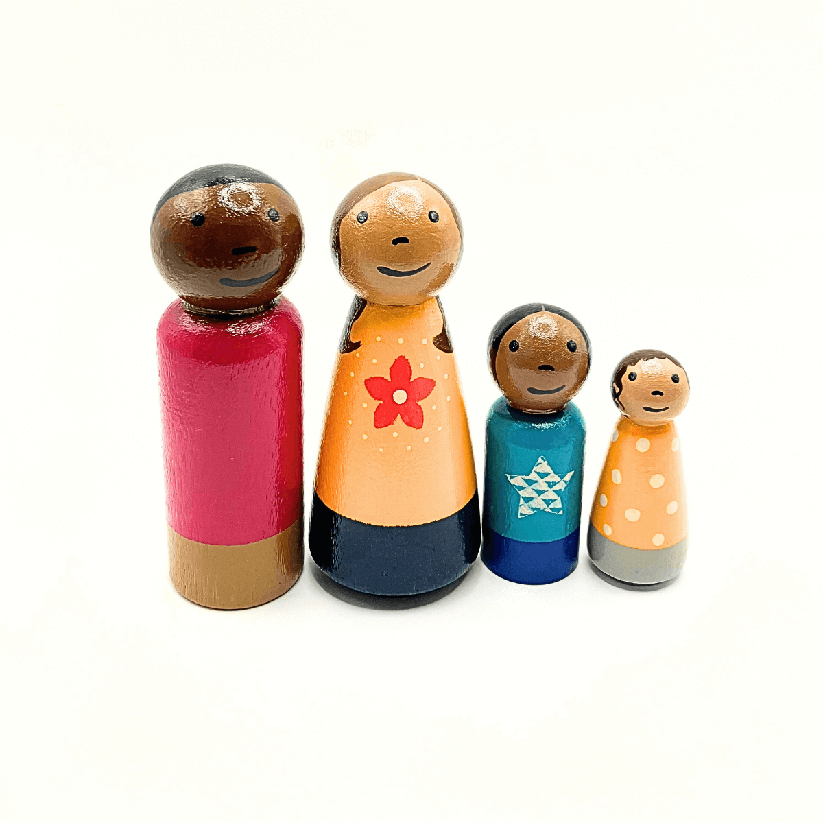 Set of four wooden peg dolls with colorful outfits on a white background