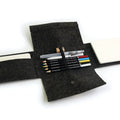 Dark gray felt pencil case with water color pencils and a notebook on a white background