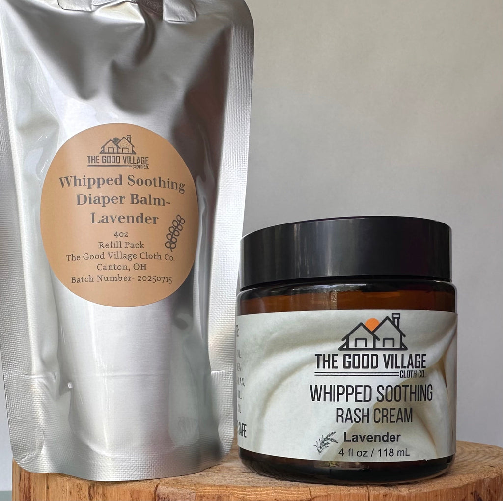 Whipped soothing diaper balm and rash cream from The Good Village on a wooden surface.