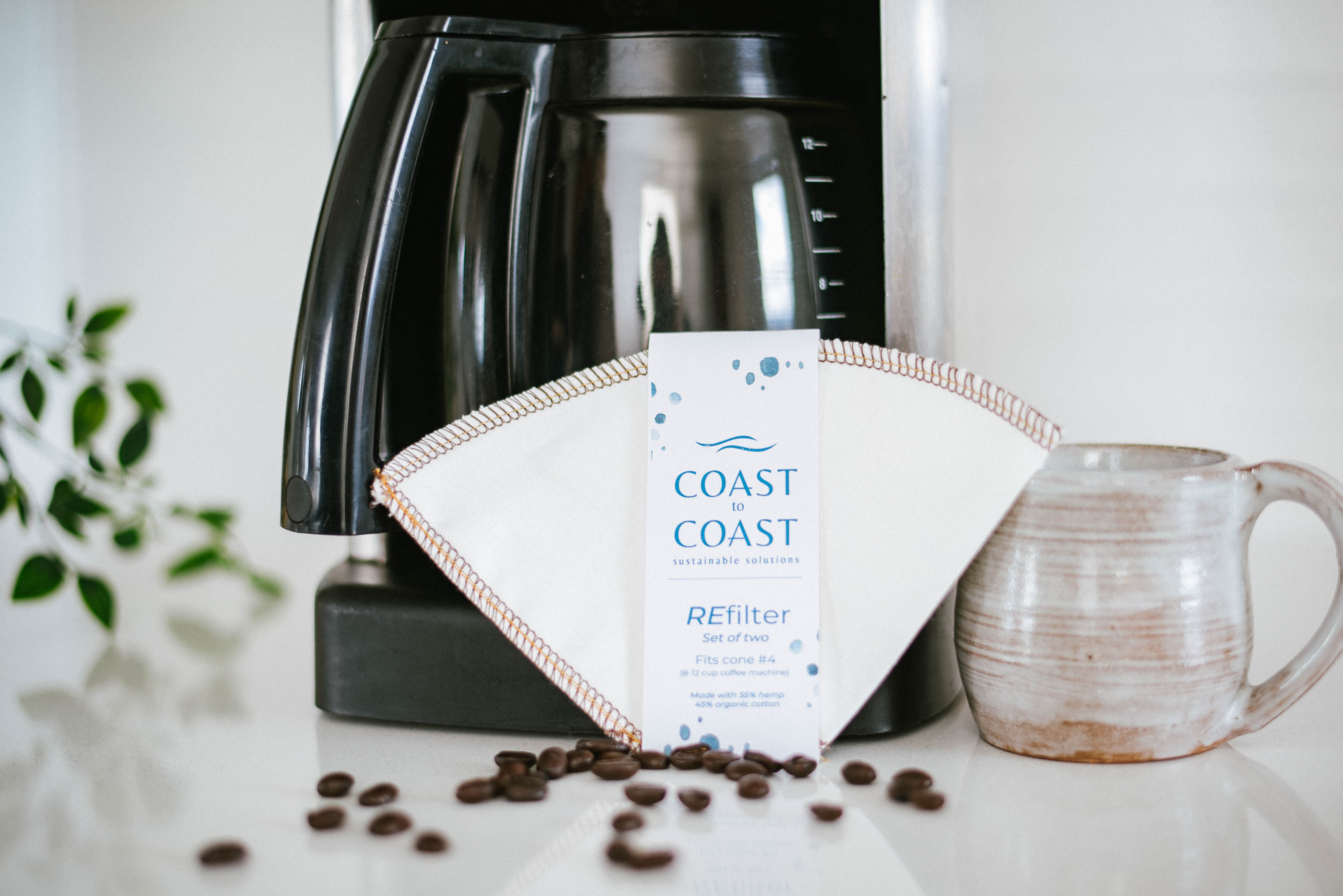 Coast to Coast coffee filter with a coffee maker and mug on a countertop