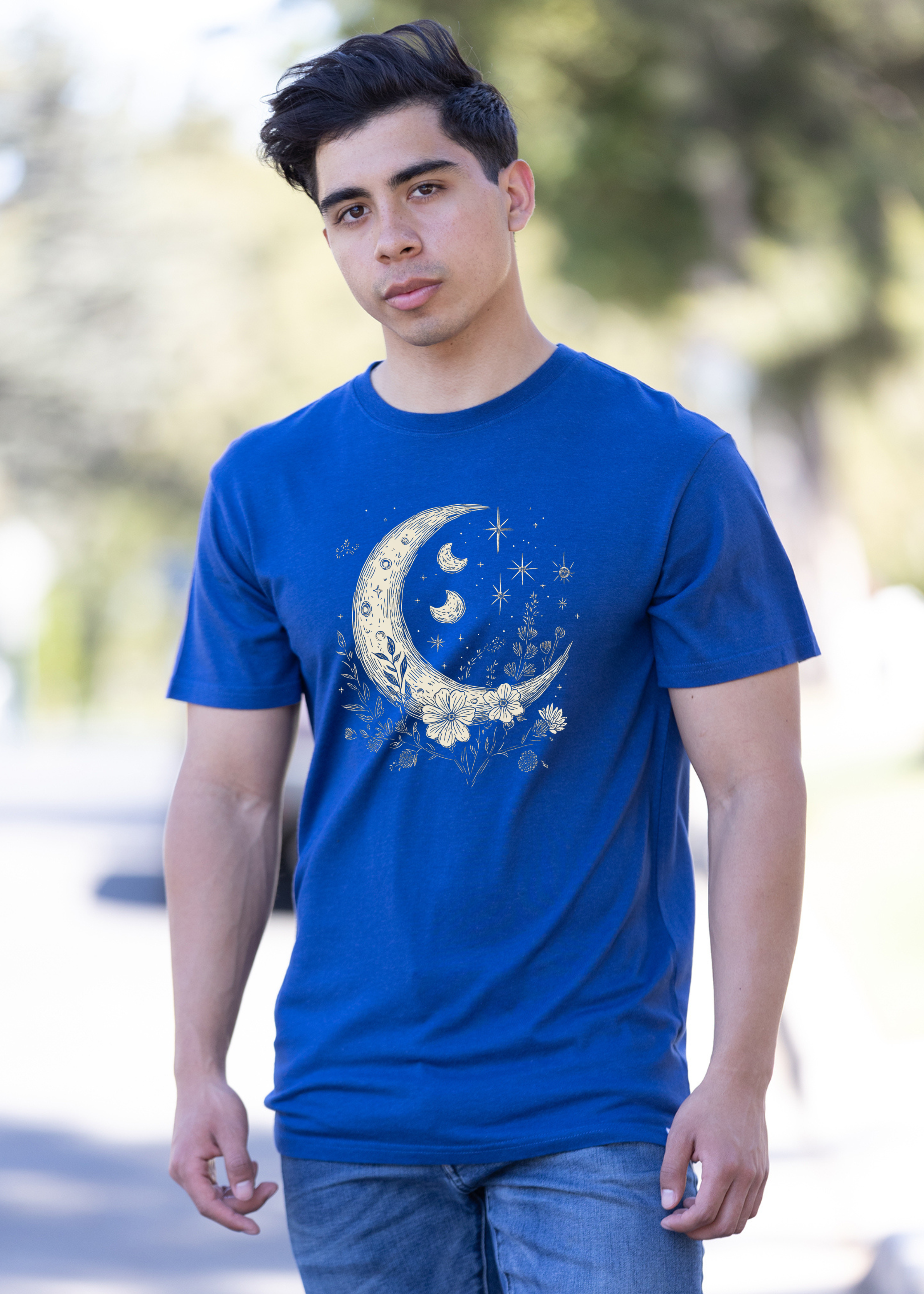 Person wearing a blue t-shirt with a moon and star design outdoors