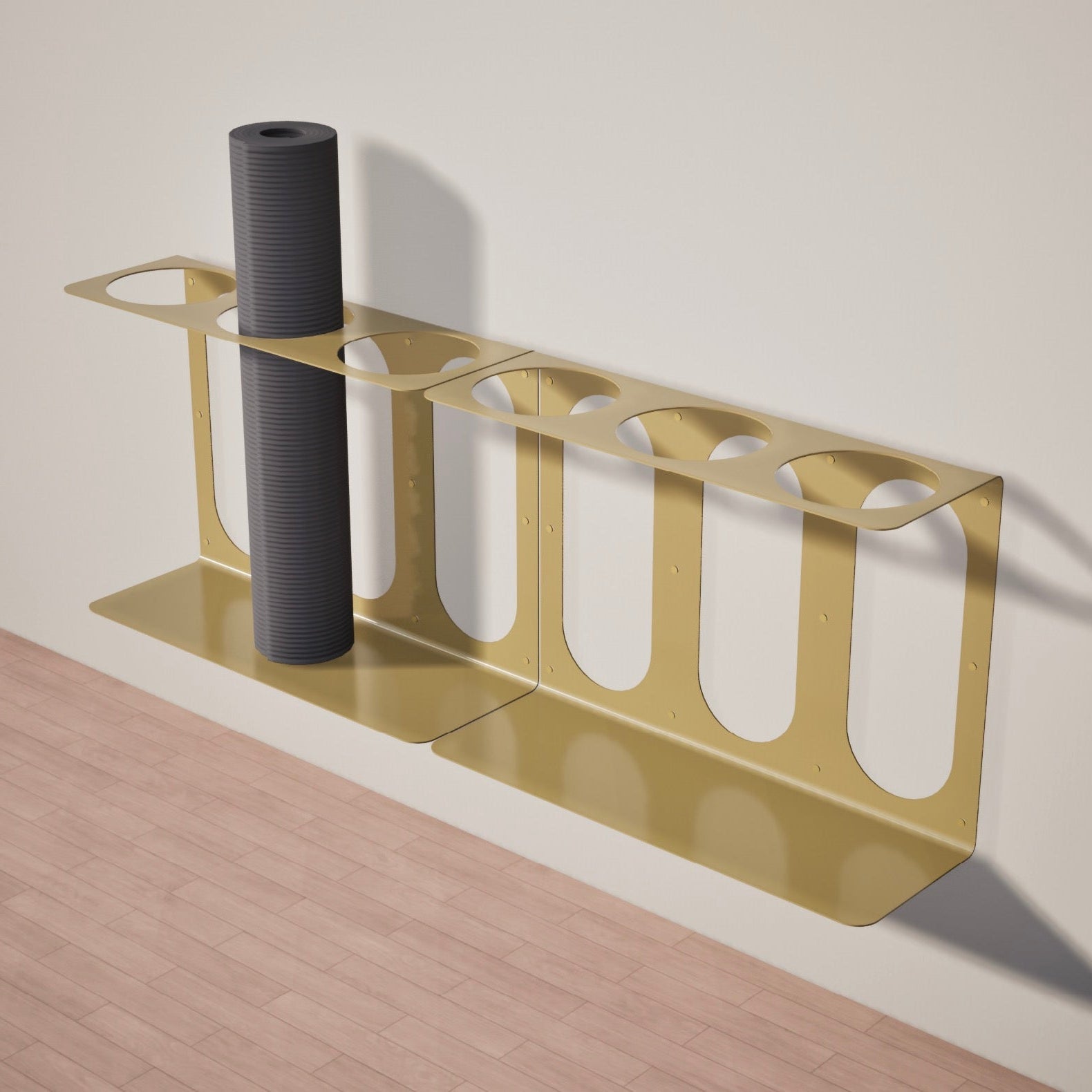 2 gold yoga mat stands with 3 places ea. to hold mats attached to a white wall above a wooden floor.