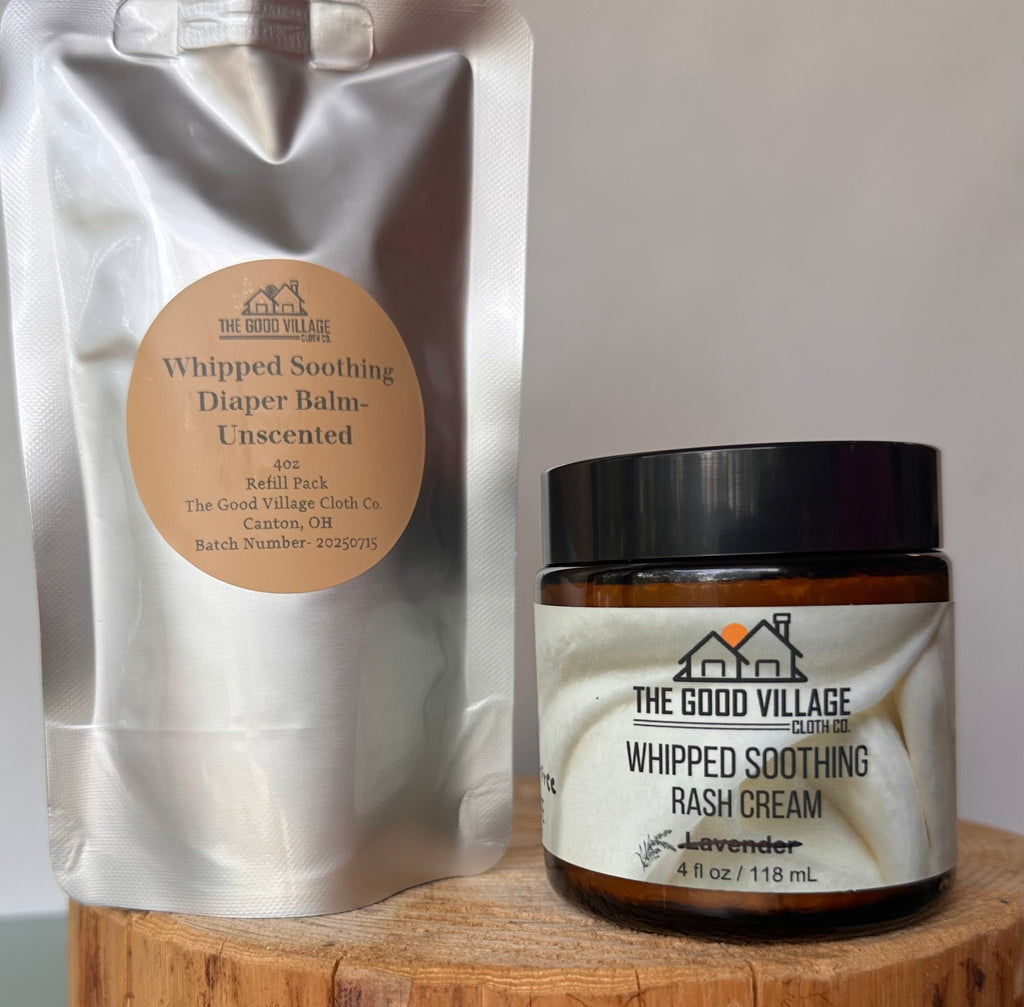 Whipped soothing diaper balm and rash cream from The Good Village on a wooden surface.