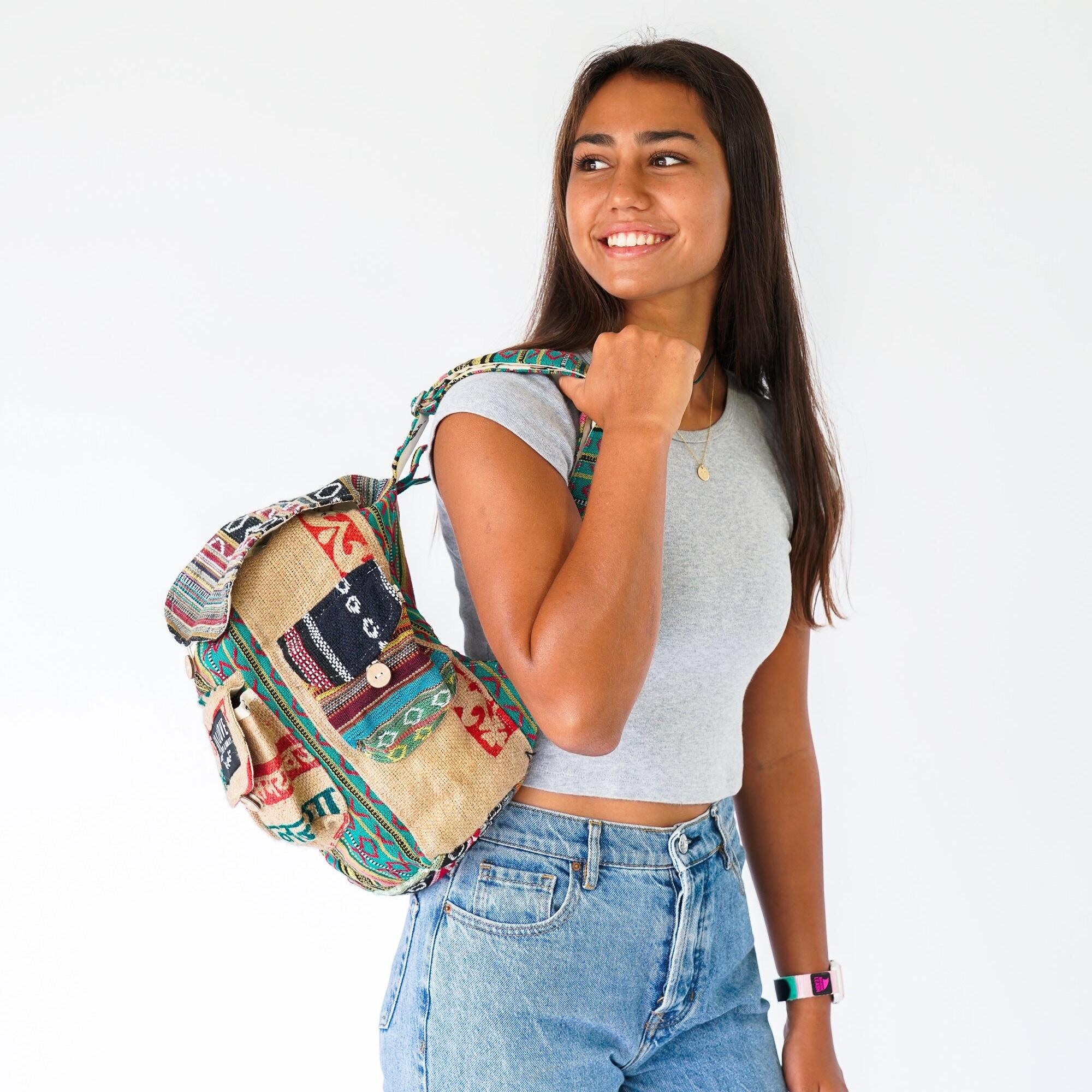 Woman holding a colorful backpack against a white background