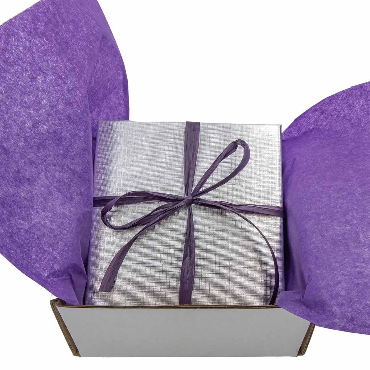 Gift box with silver wrapping paper and purple ribbon on a white background