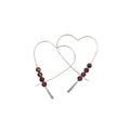 Heart-shaped earrings with red beads on a white background