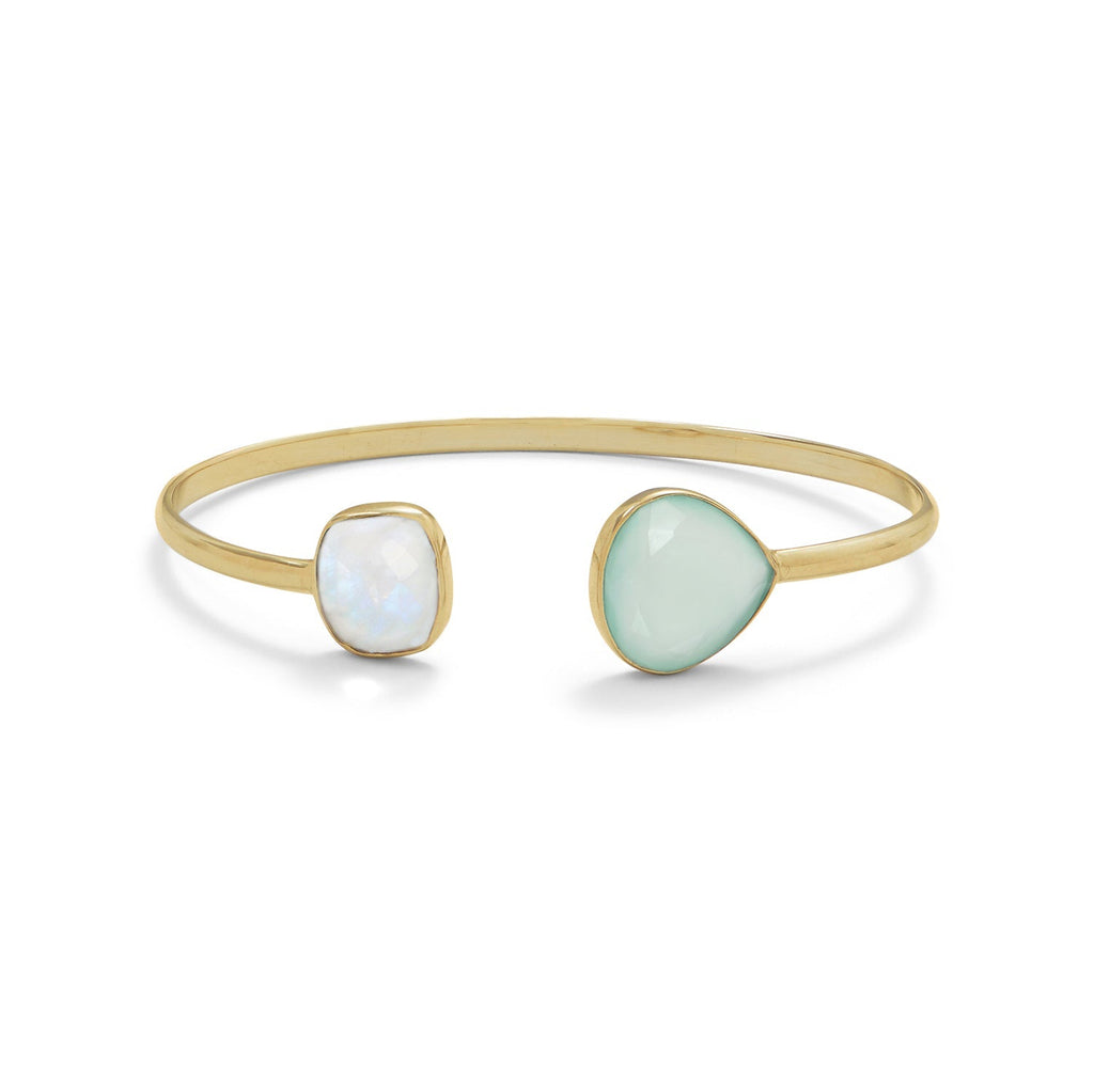 Gold bangle with two gemstones, one white and one light green, on a white background
