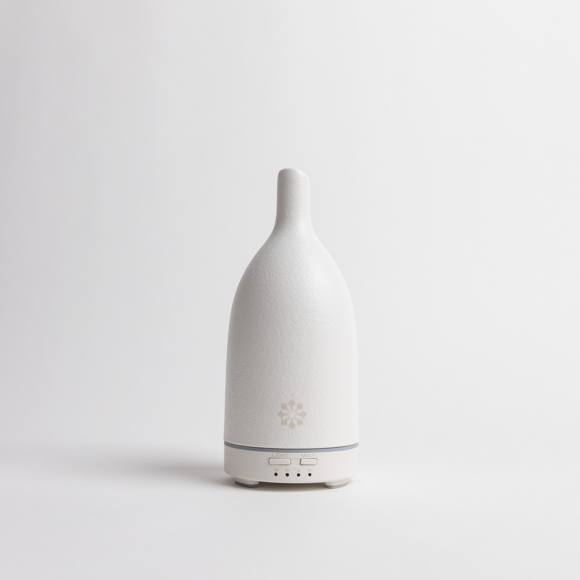 White essential oil diffuser on a light gray background