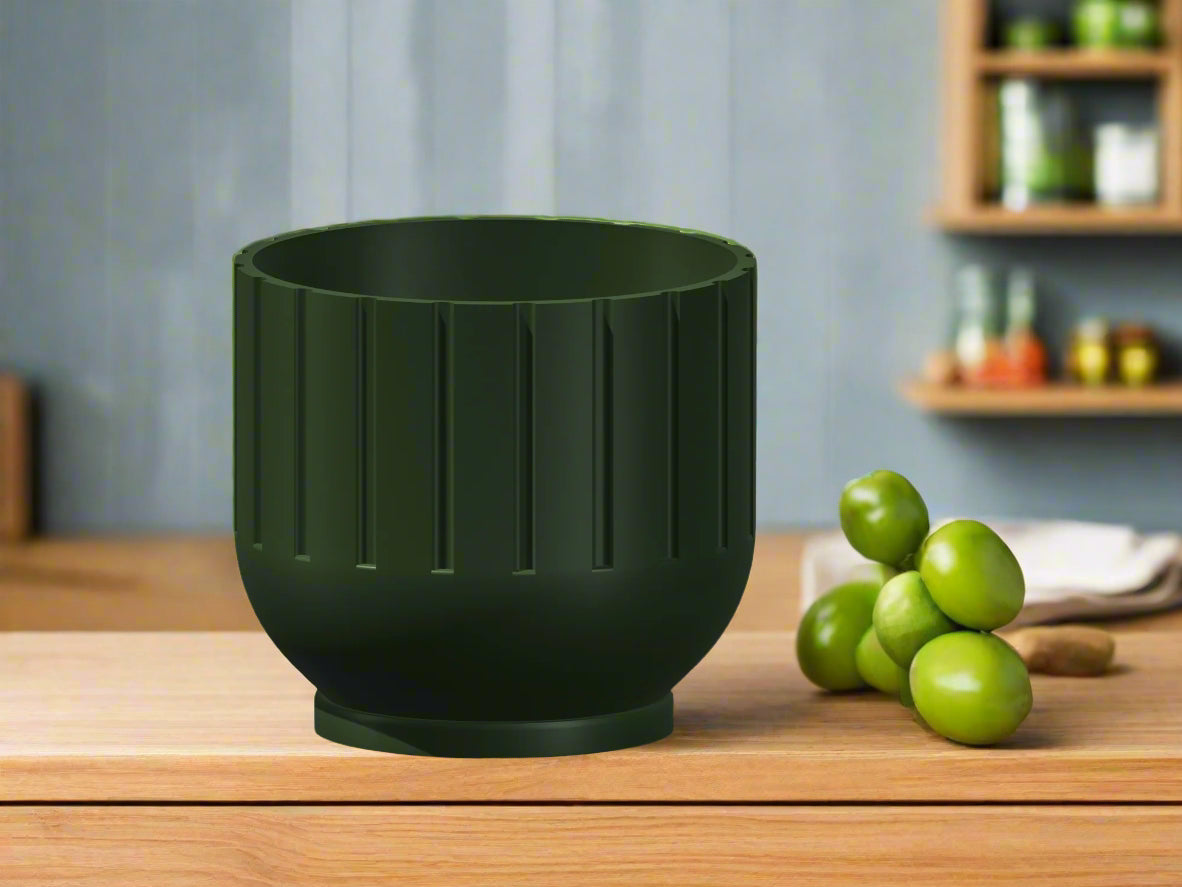 Green planter on a wooden surface with green fruits in the background
