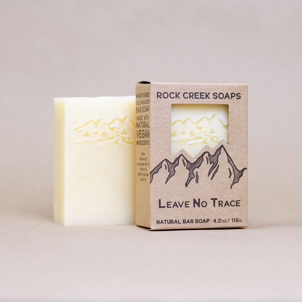 Bar of soap with 'Rock Creek Soaps' 'Leave No Trace' soap bar with  packaging on a light background