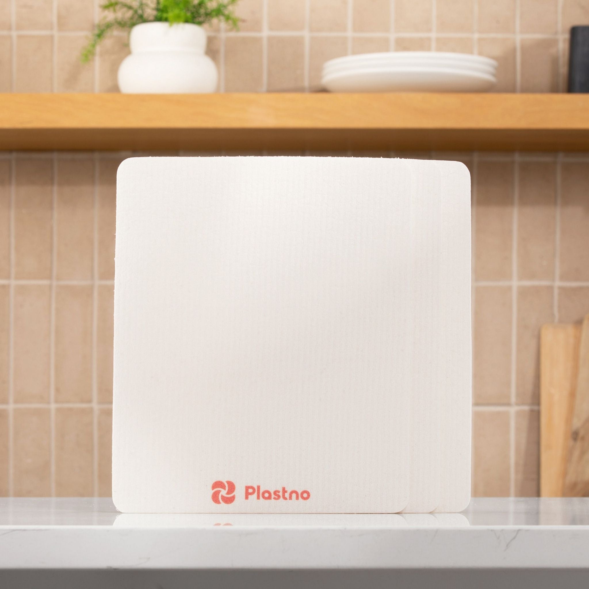 White sponge towel with Plastno logo on a kitchen counter