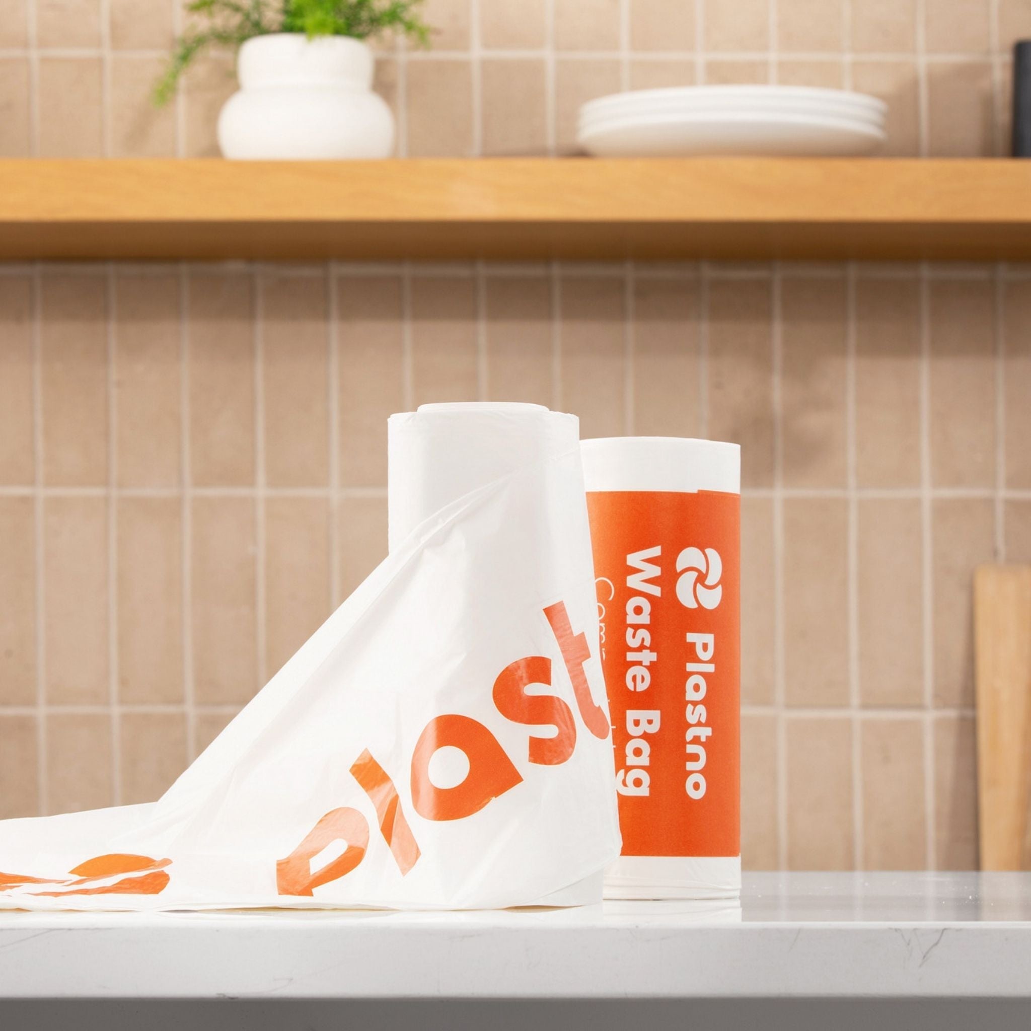 Plastno waste bags on a kitchen counter with a tiled wall background