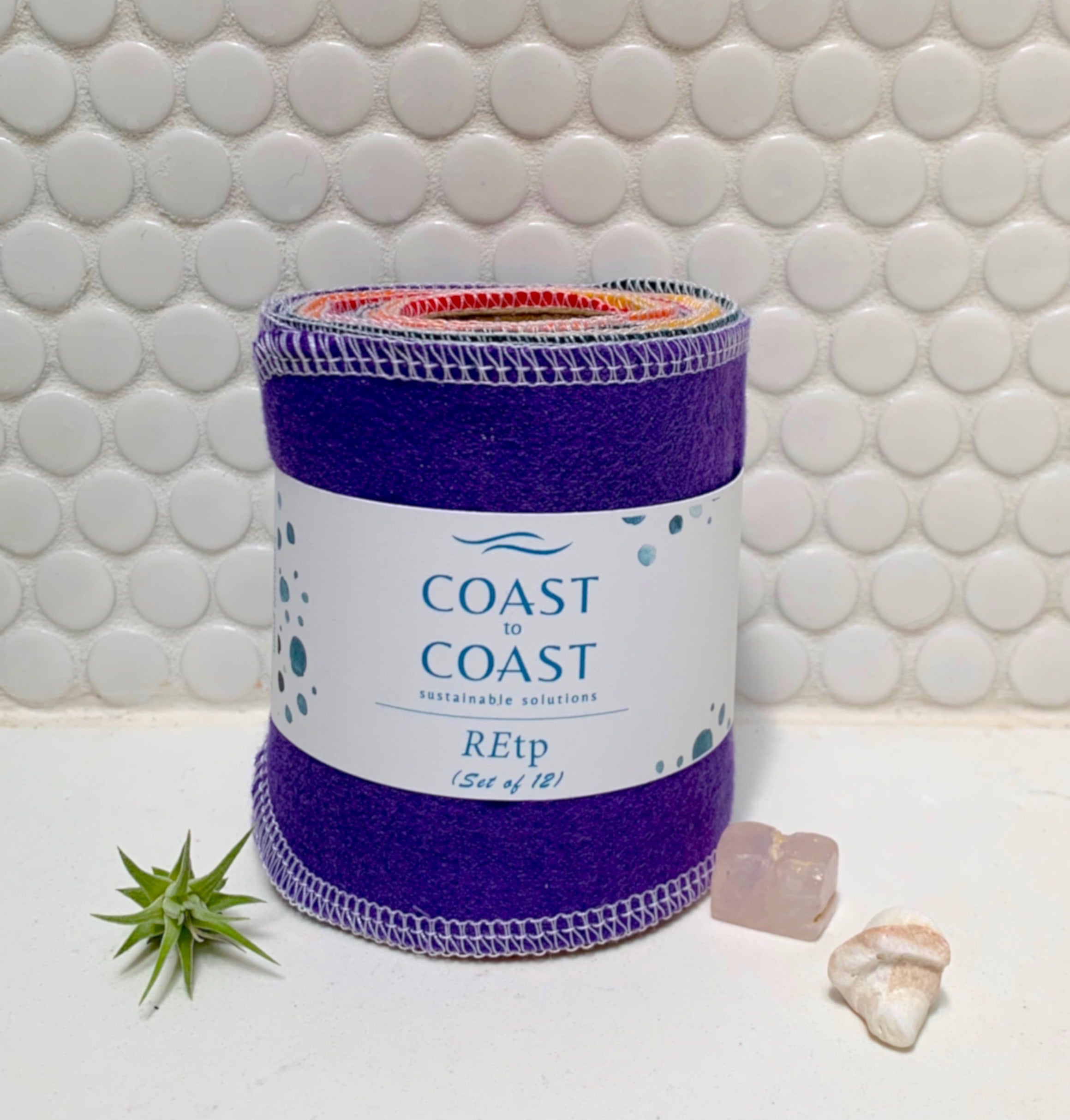 Coast to Coast REtp product on a tiled bathroom floor with a plant and seashell.