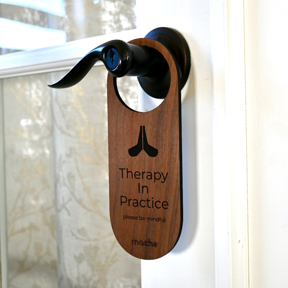 Dark wooden door handle hanger with engraved text on a white door