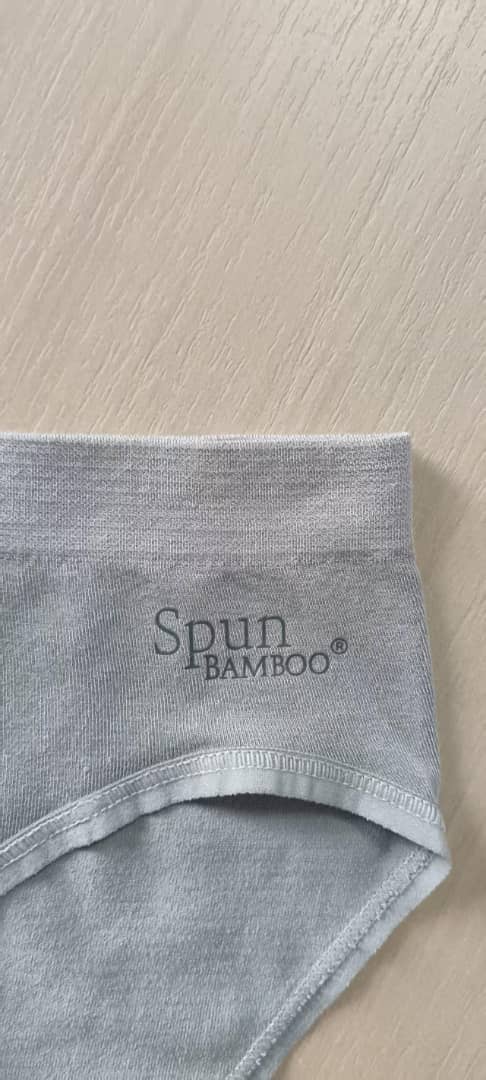 Gray bamboo underwear on a light wood surface with 'Spun Bamboo' branding.