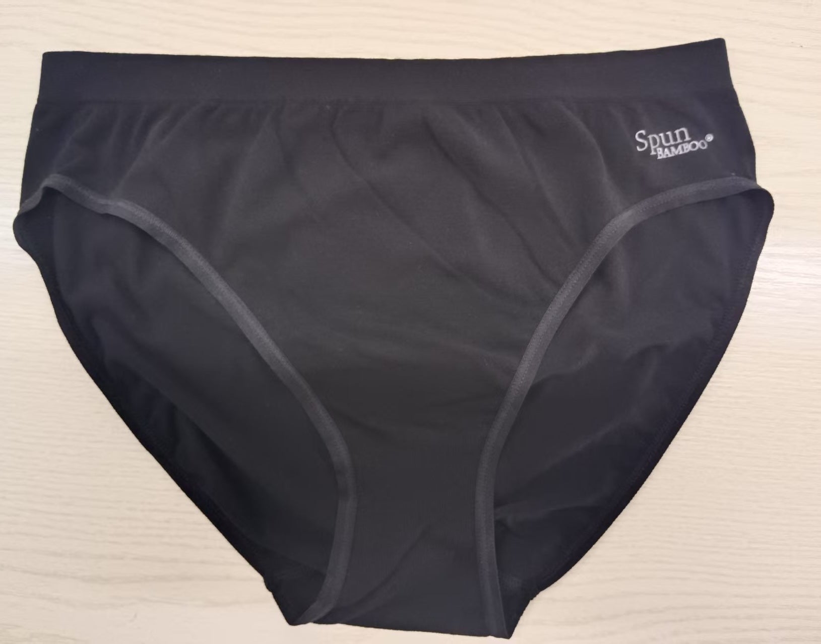 Women's black underwear with ' spun bamboo' label on a beige background