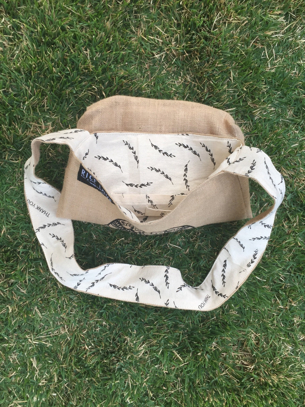 Beige and white bag with black patterns on grass