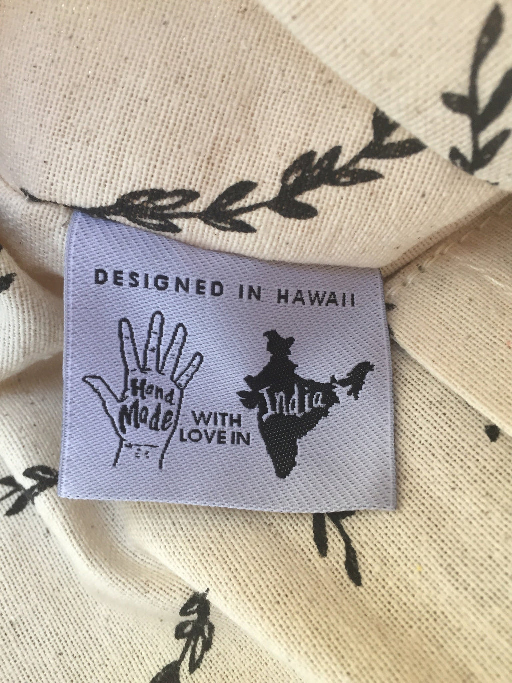 Label on a garment with text 'Designed in Hawaii, Made with Love in India'.