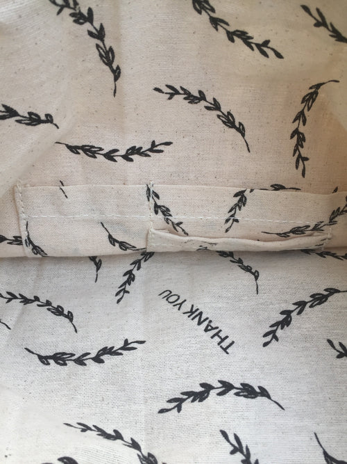 Textile with black leaf pattern and 'THANK YOU' text on beige fabric