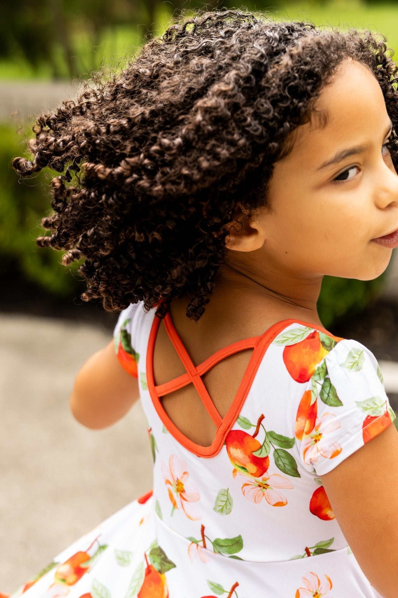 Young girl wearing a dress with a floral pattern outdoors