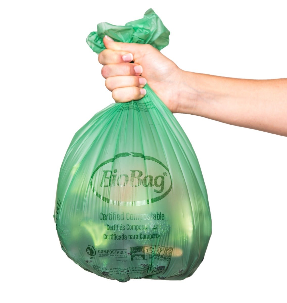 Hand holding a green compostable bag labeled 'BioBag' on a white background