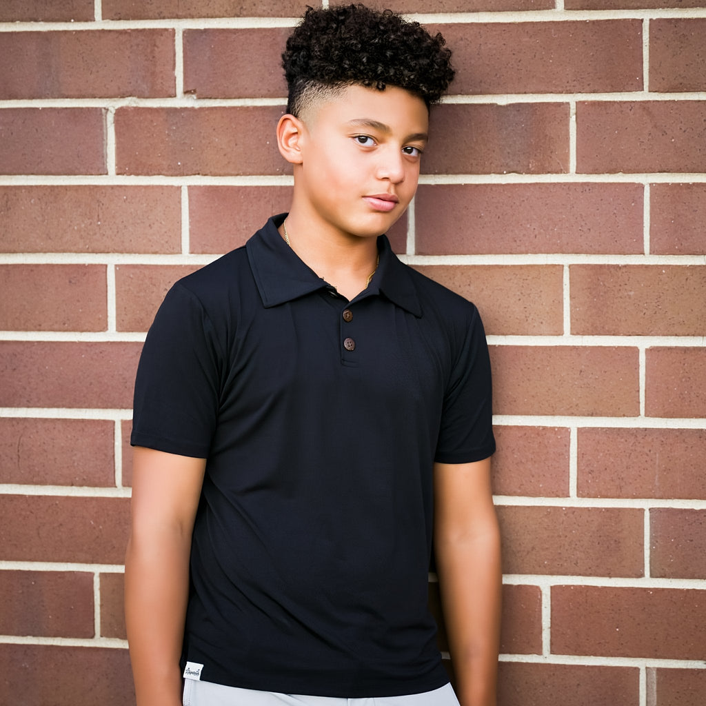 Person wearing a black polo shirt against a brick wall