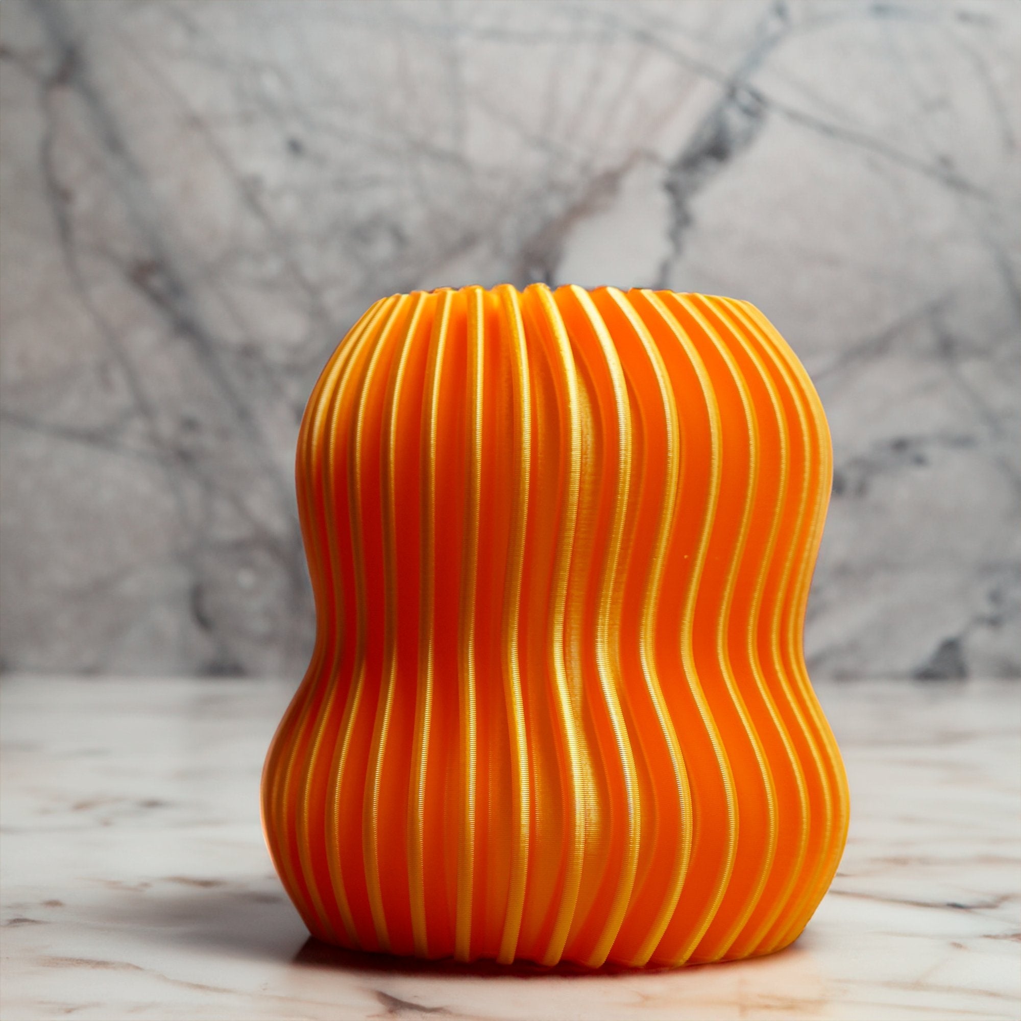Orange textured vase on a marble surface with a marble background
