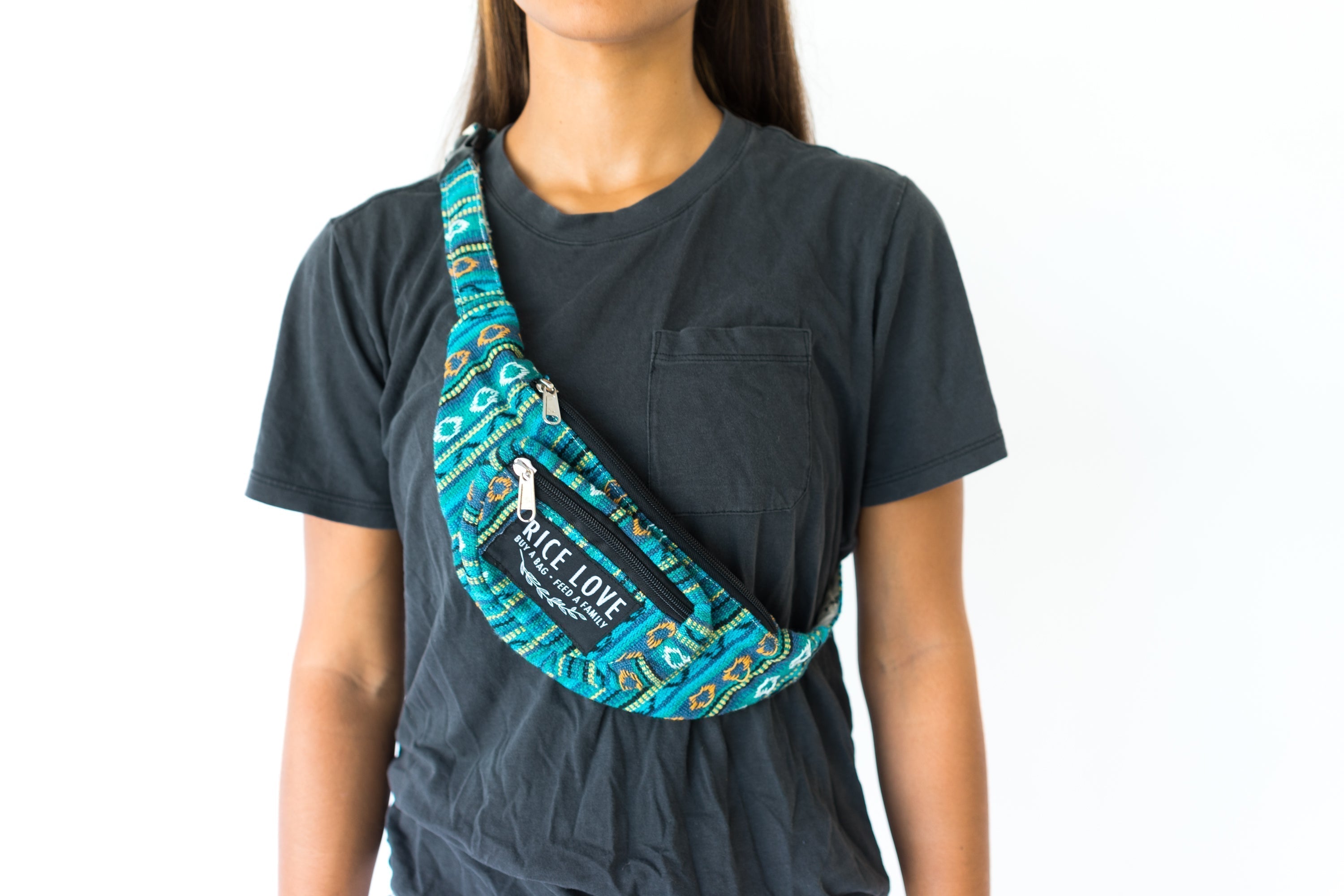 Person wearing a black t-shirt with a blue patterned crossbody bag.