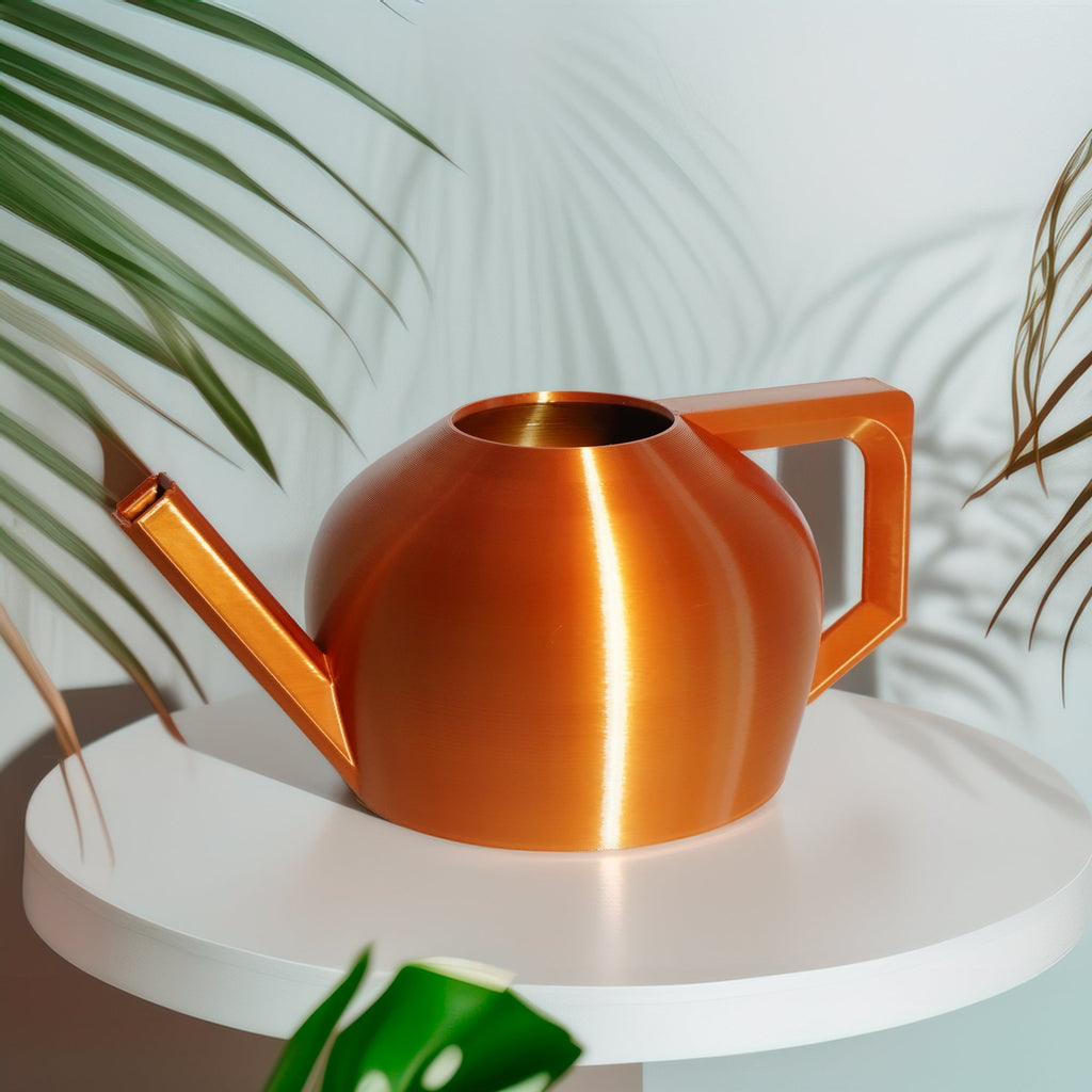 Gold watering can on a white surface with green plants in the background