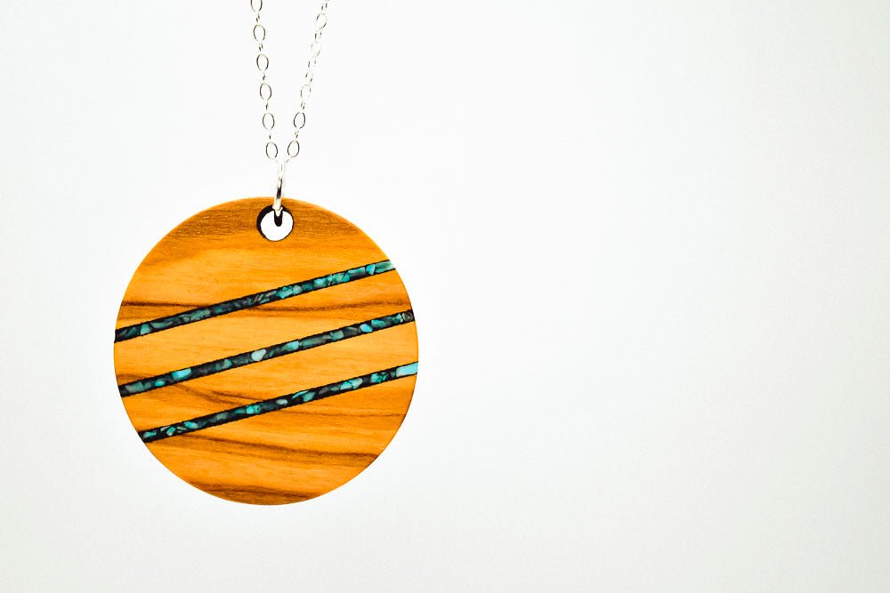Wooden pendant with a striped pattern on a white background