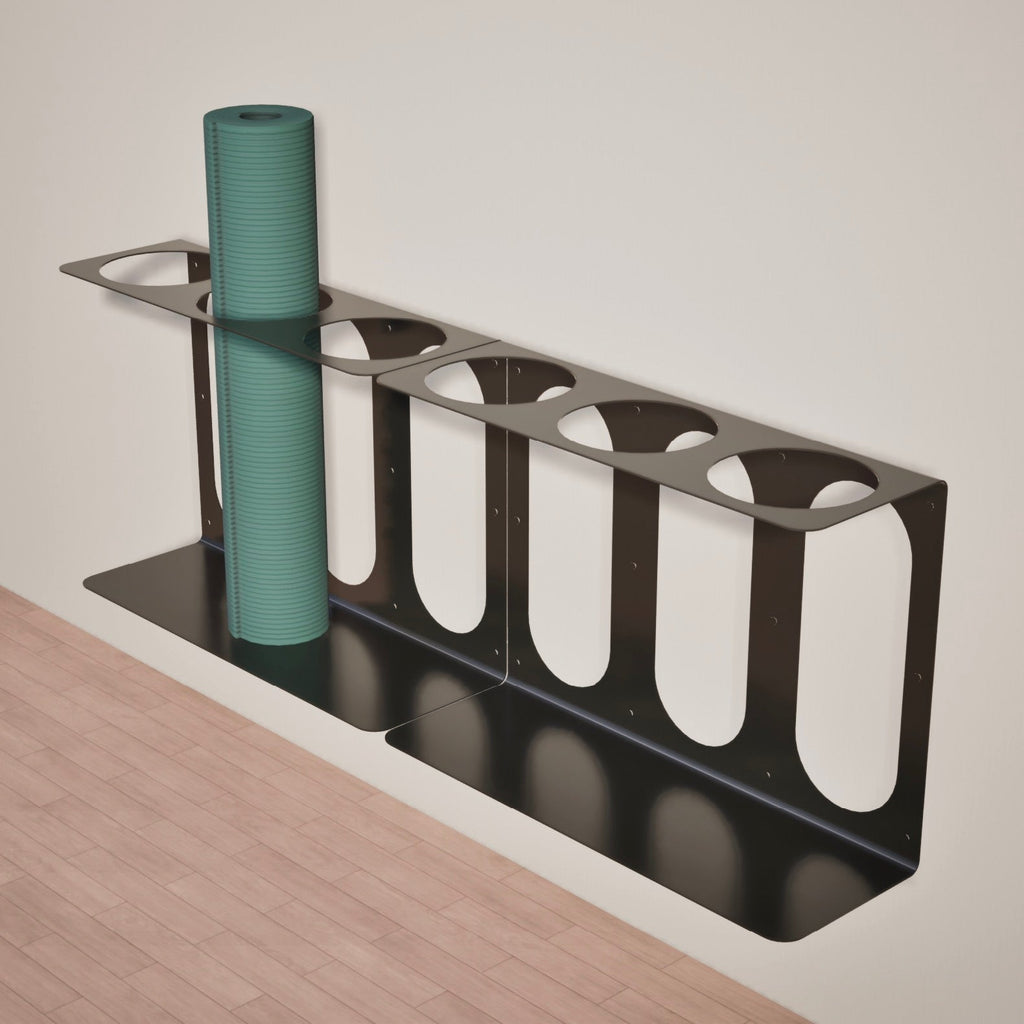 2 black yoga mat stands with 3 places ea. to hold mats attached to a white wall above a wooden floor.