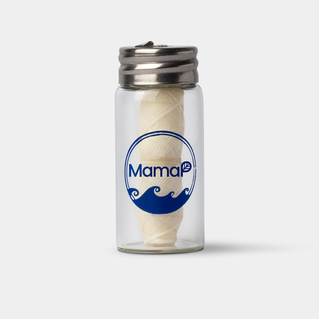 Eco-friendly, refillable dental floss in a glass jar with 'Mama' logo on a white background