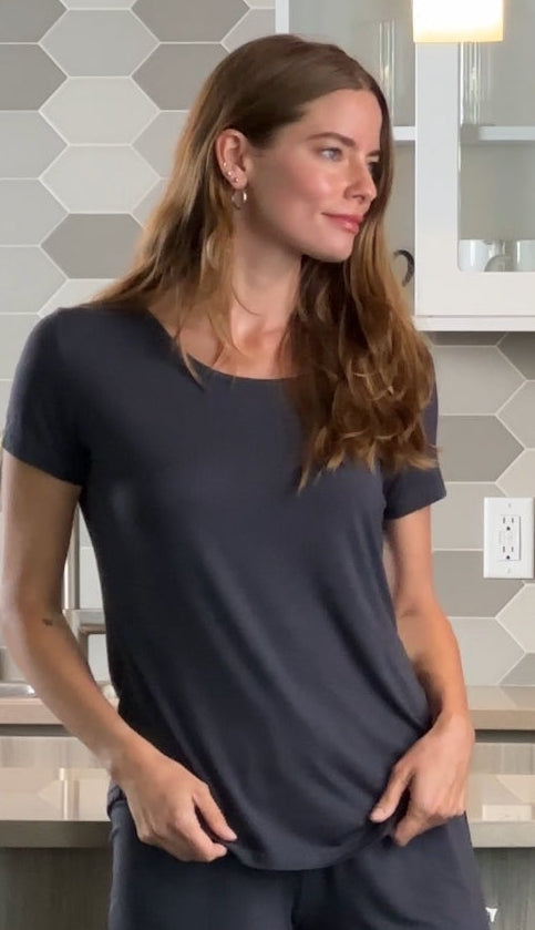 Woman wearing a navy blue t-shirt in a kitchen setting