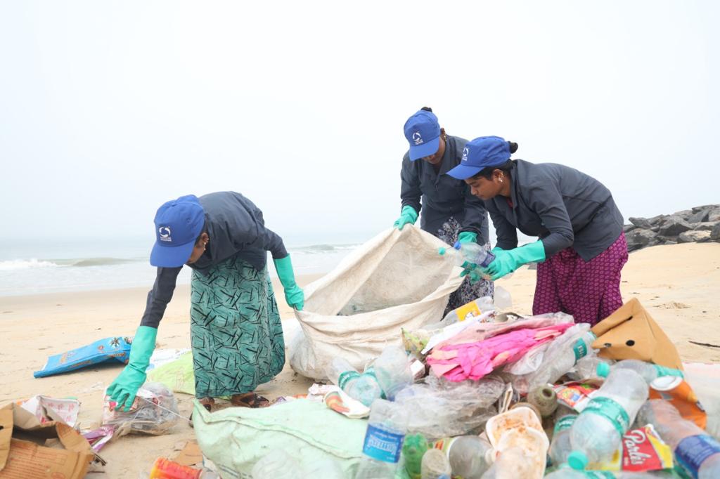 People sorting through trash on a beach