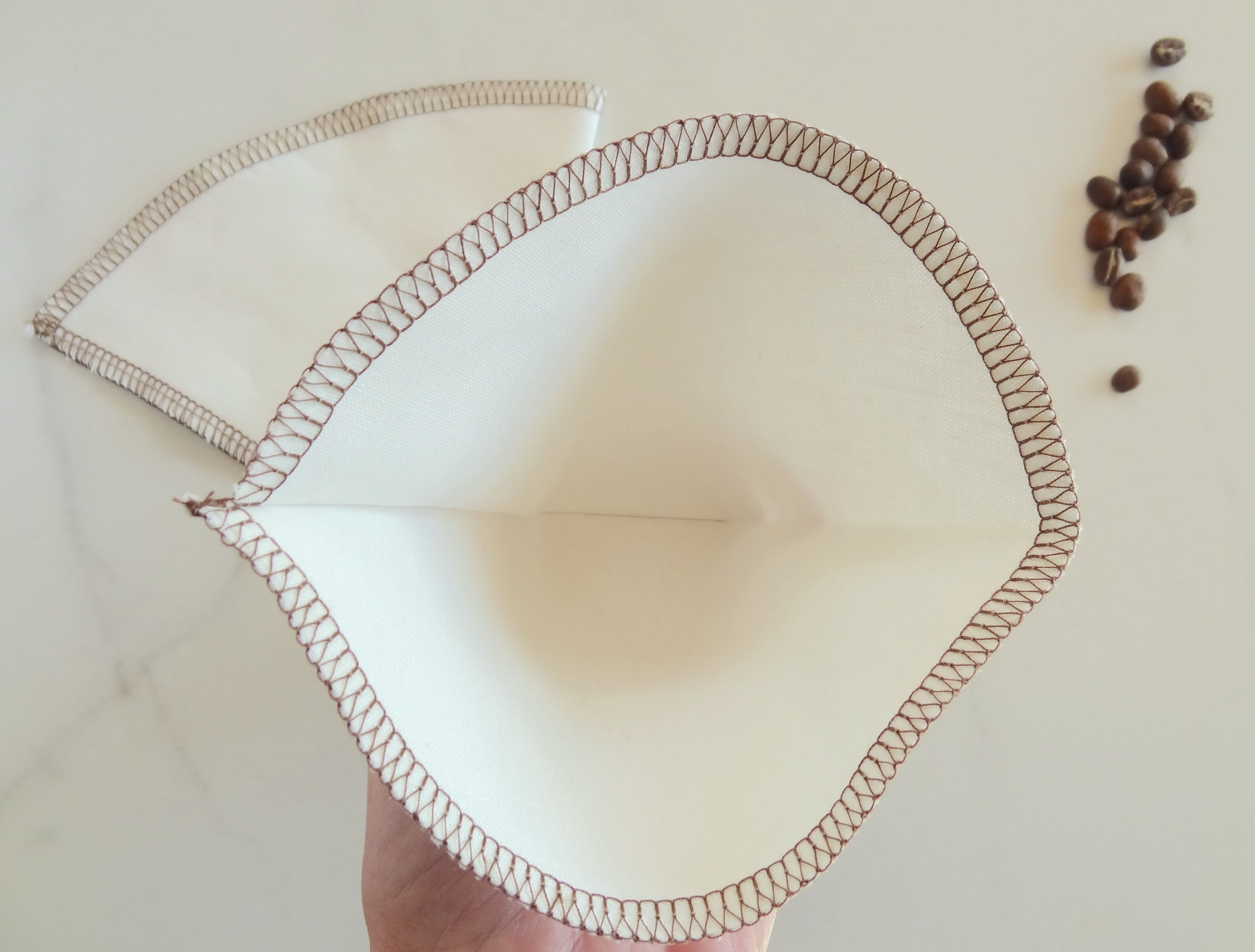 Coffee filter with brown trim on a light background