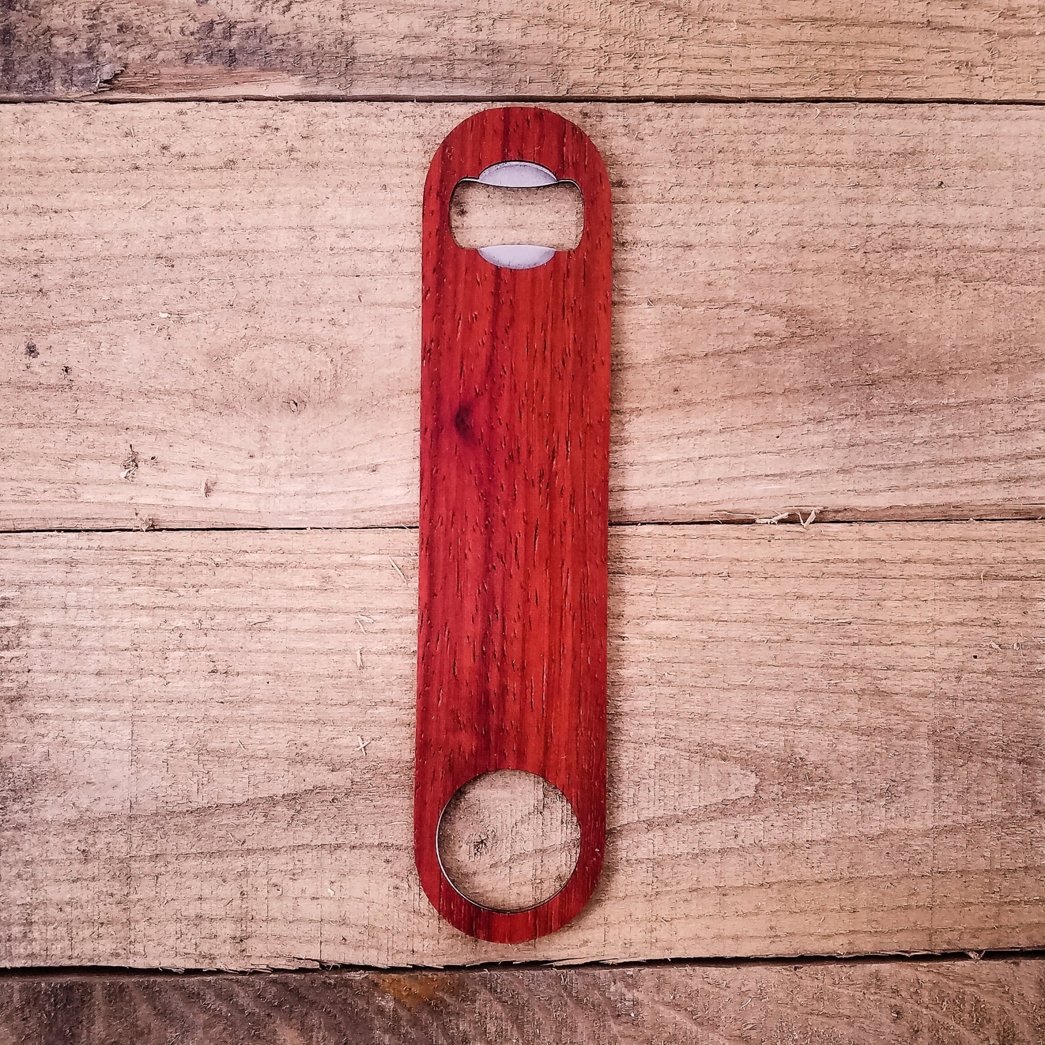 Red wooden bottle opener on a wooden surface