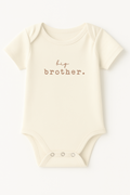 Beige baby onesie with 'big brother' text on a white background