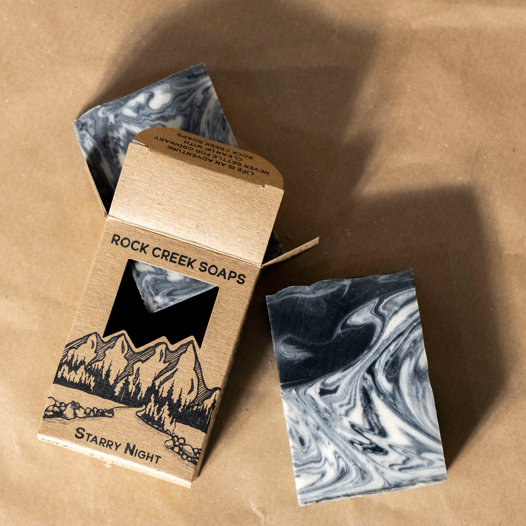 Marbled soap bars with packaging on brown background.