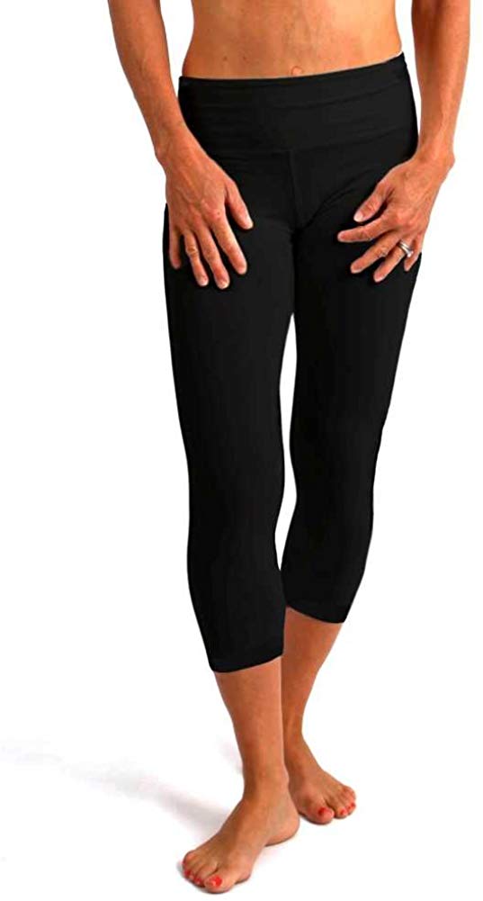 Person wearing black capri leggings on a white background