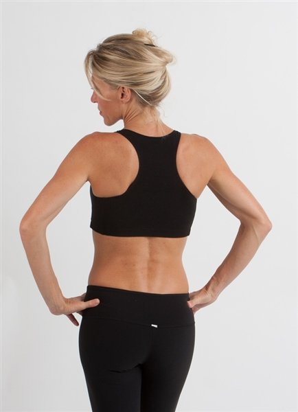 Person wearing a black sports bra and leggings on a plain background
