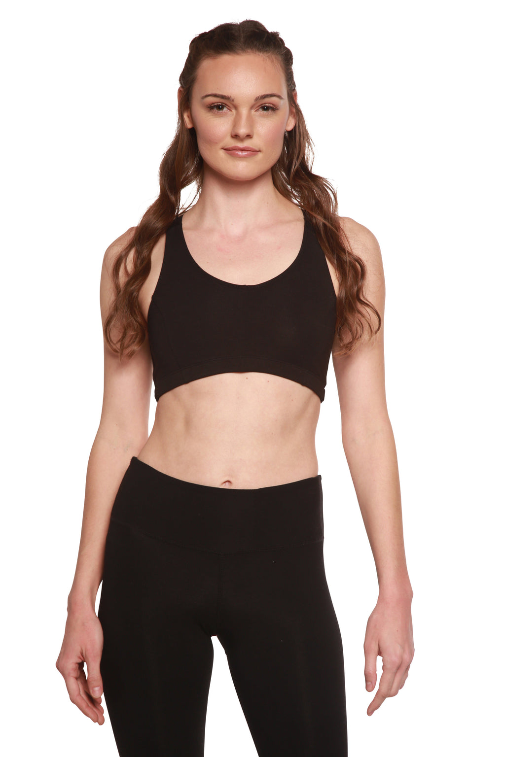 Woman wearing a black sports bra and leggings on a white background