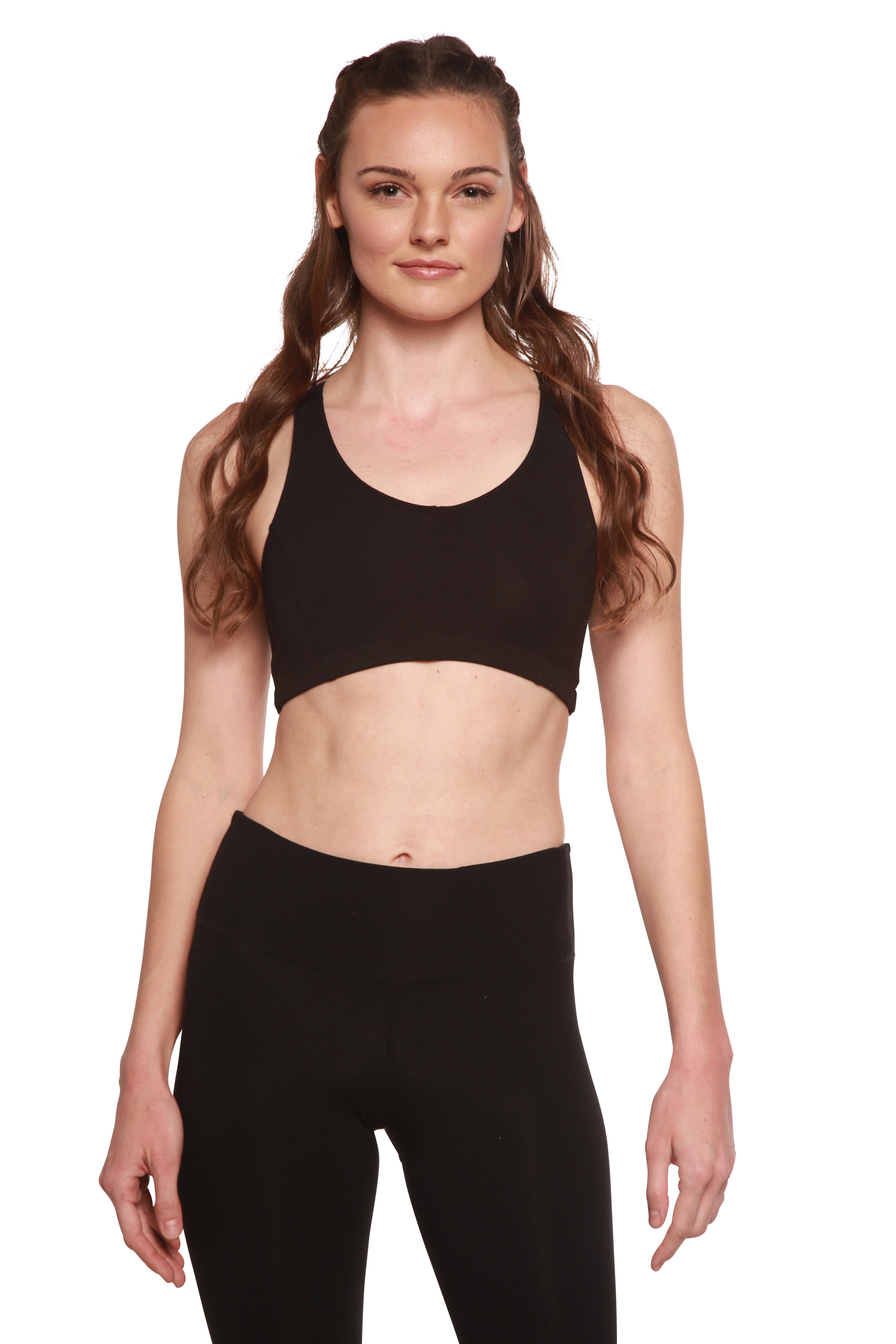 Woman wearing a black sports bra and leggings on a white background